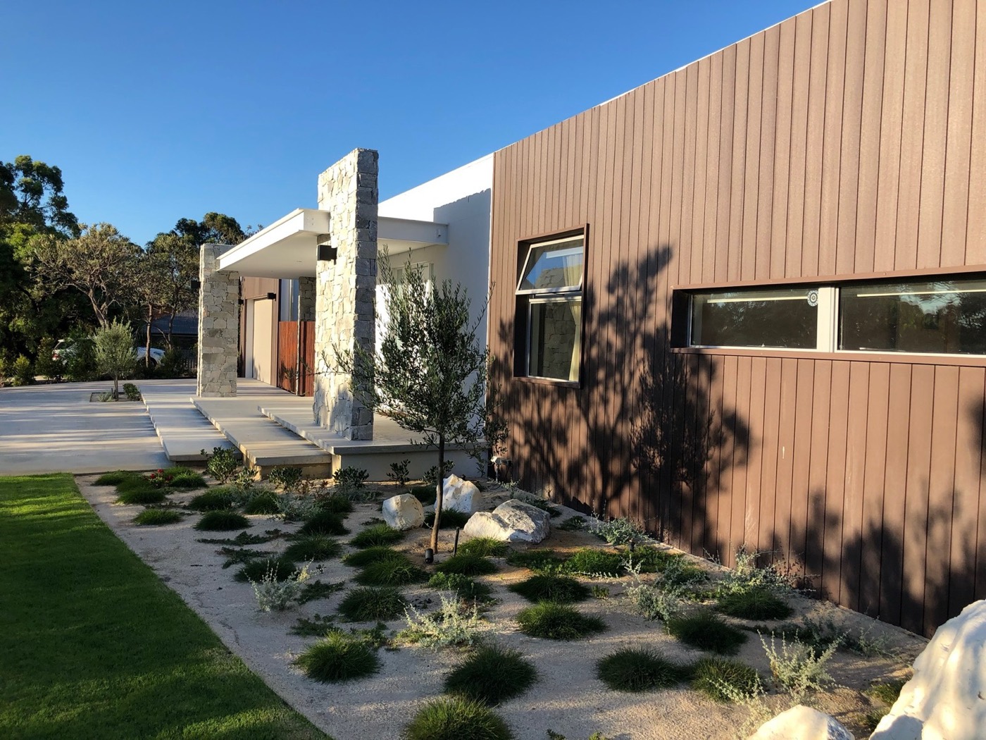 Mid-century-inspired Jandakot residence with timber cladding, stone walls and landscaped garden
