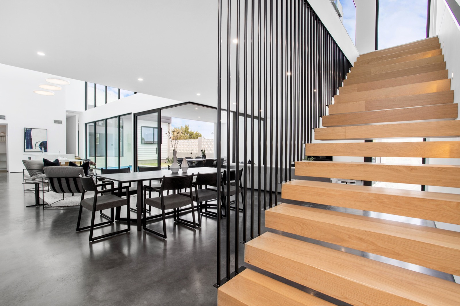 Open-plan living area with timber staircase and black balustrade