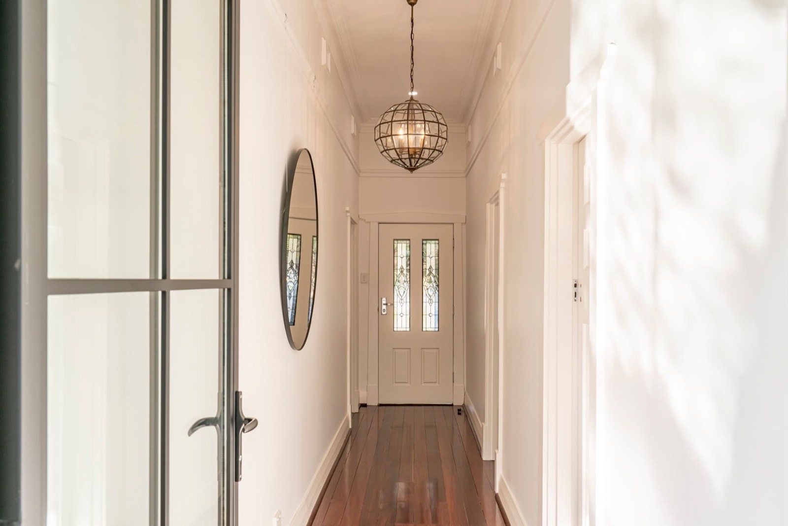 Restored entry hallway with original timber floor and leadlight door