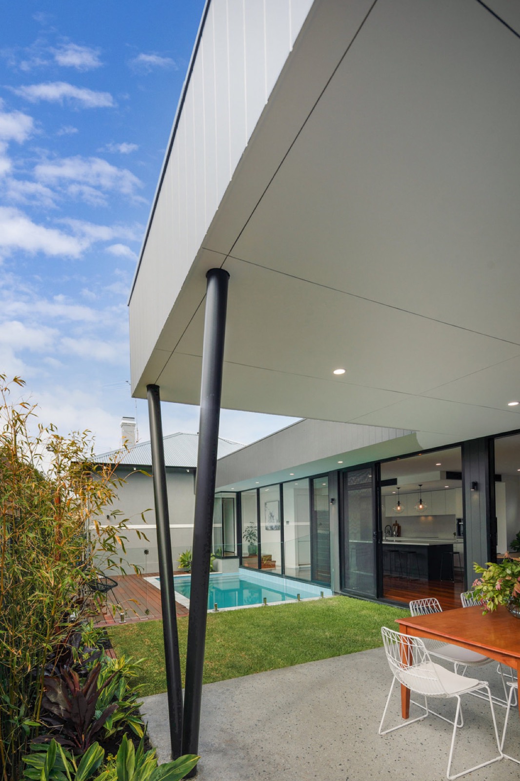 Modern roofline and slender black columns framing the courtyard