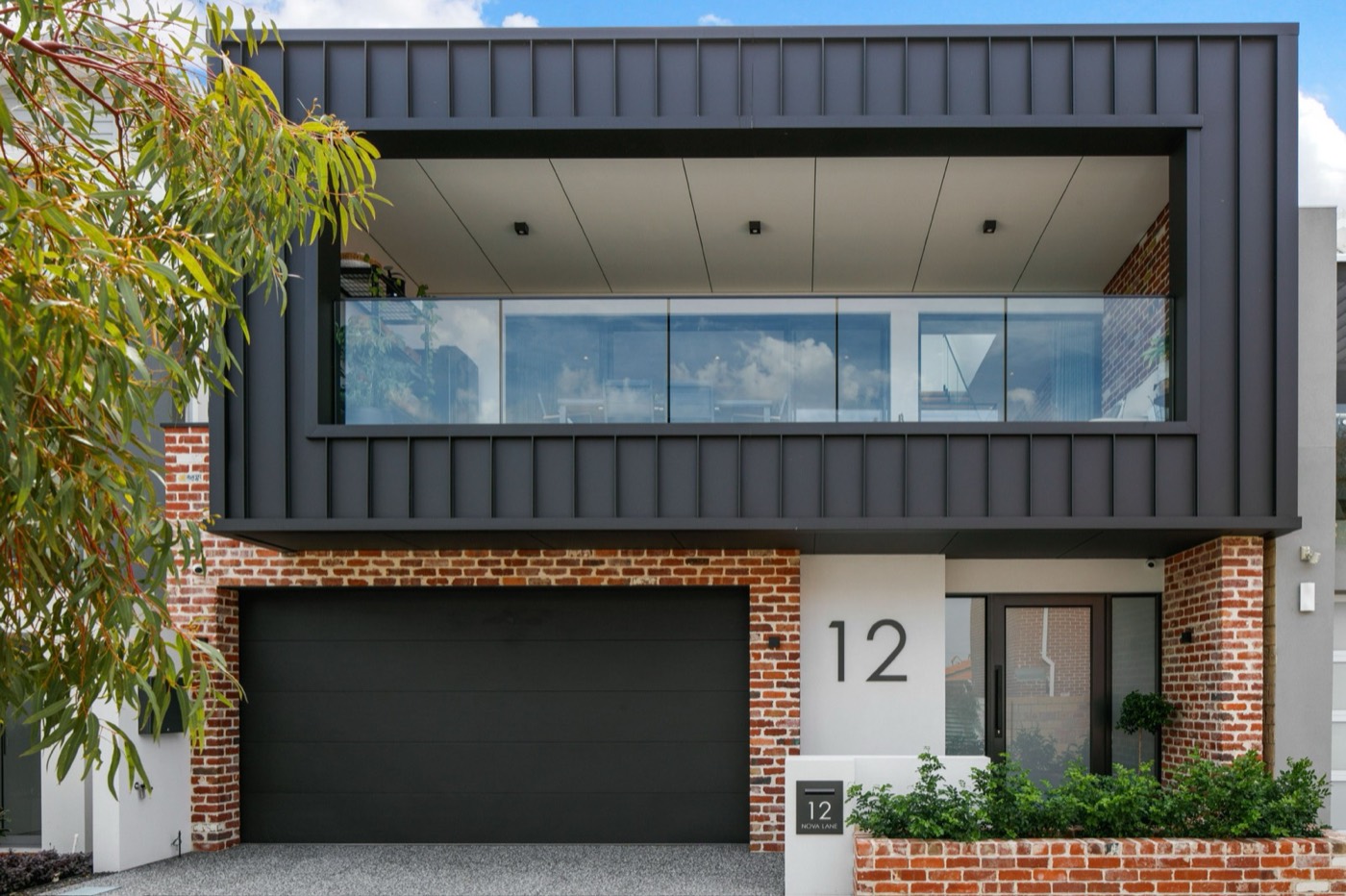 Nova Lane new build with red brick, black steel cladding and a glazed upper balcony