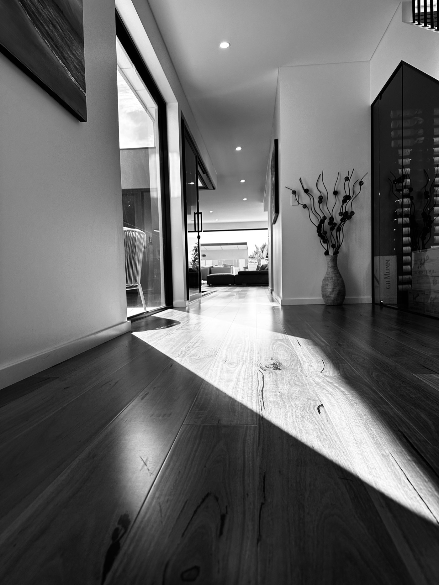 Black-and-white interior view with sunlight falling across timber floors