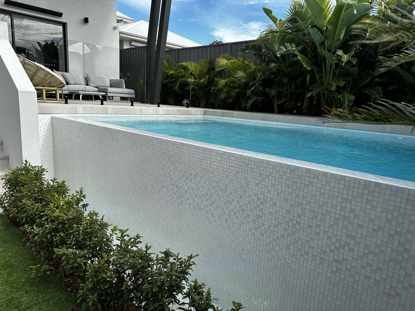 Wasley Street pool courtyard framed by tropical planting and black steel columns