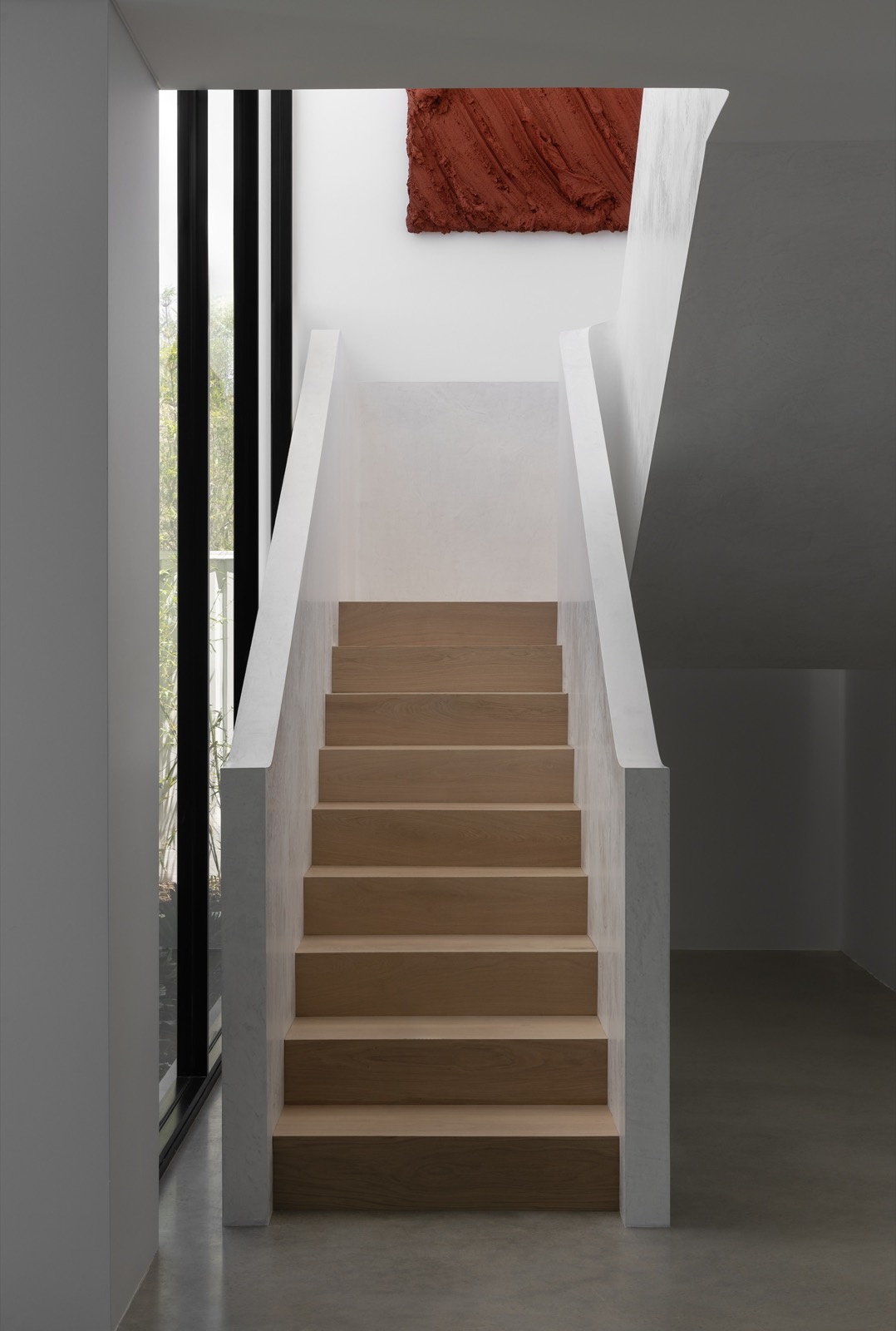 Timber stair beneath a sculptural red artwork