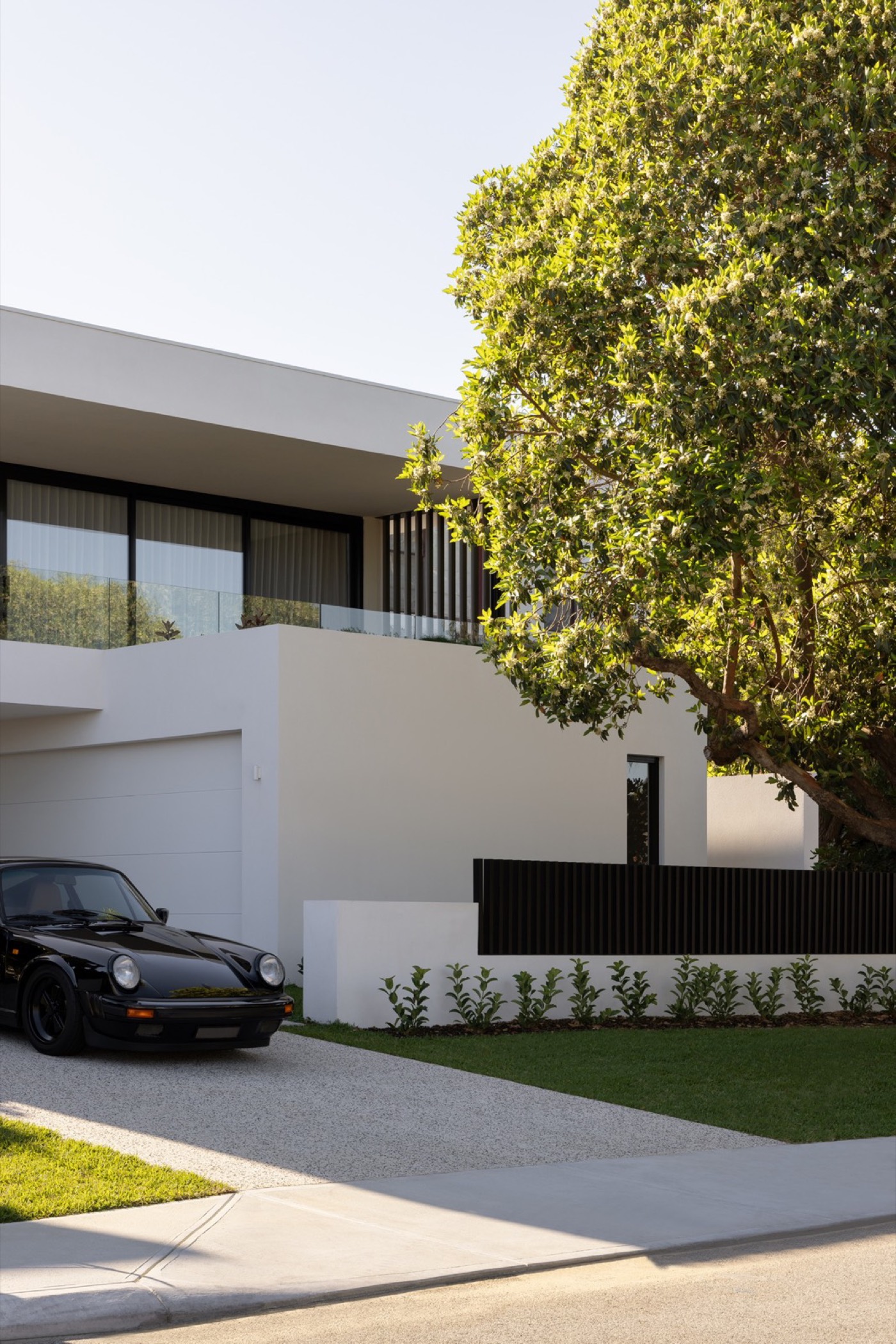 Woodlands residence street elevation framed by a mature tree